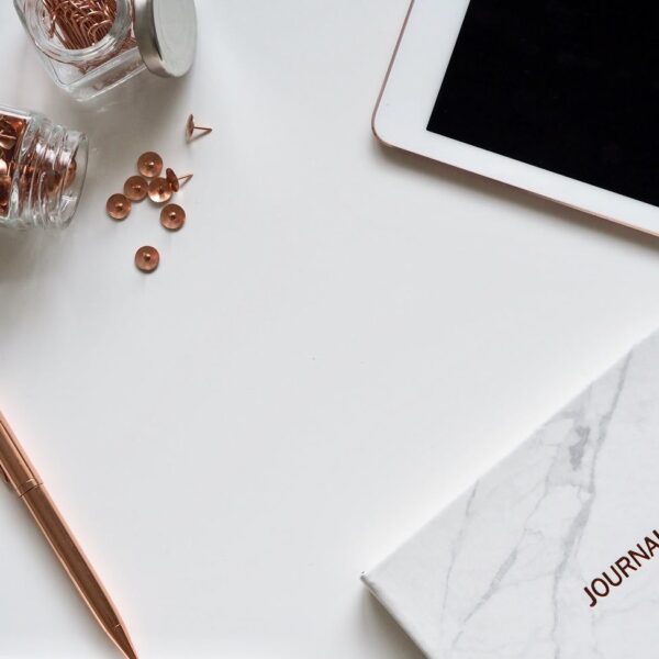 white ipad on the table near small clear glass jars